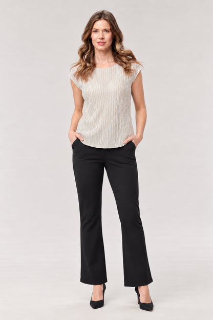 A woman modeling a sleeveless cream ribbed knit top and black flared trousers against a light gray studio background.