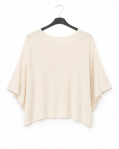 A light beige short-sleeve top with a wide, draped silhouette, hanging on a black hanger against a plain white background.