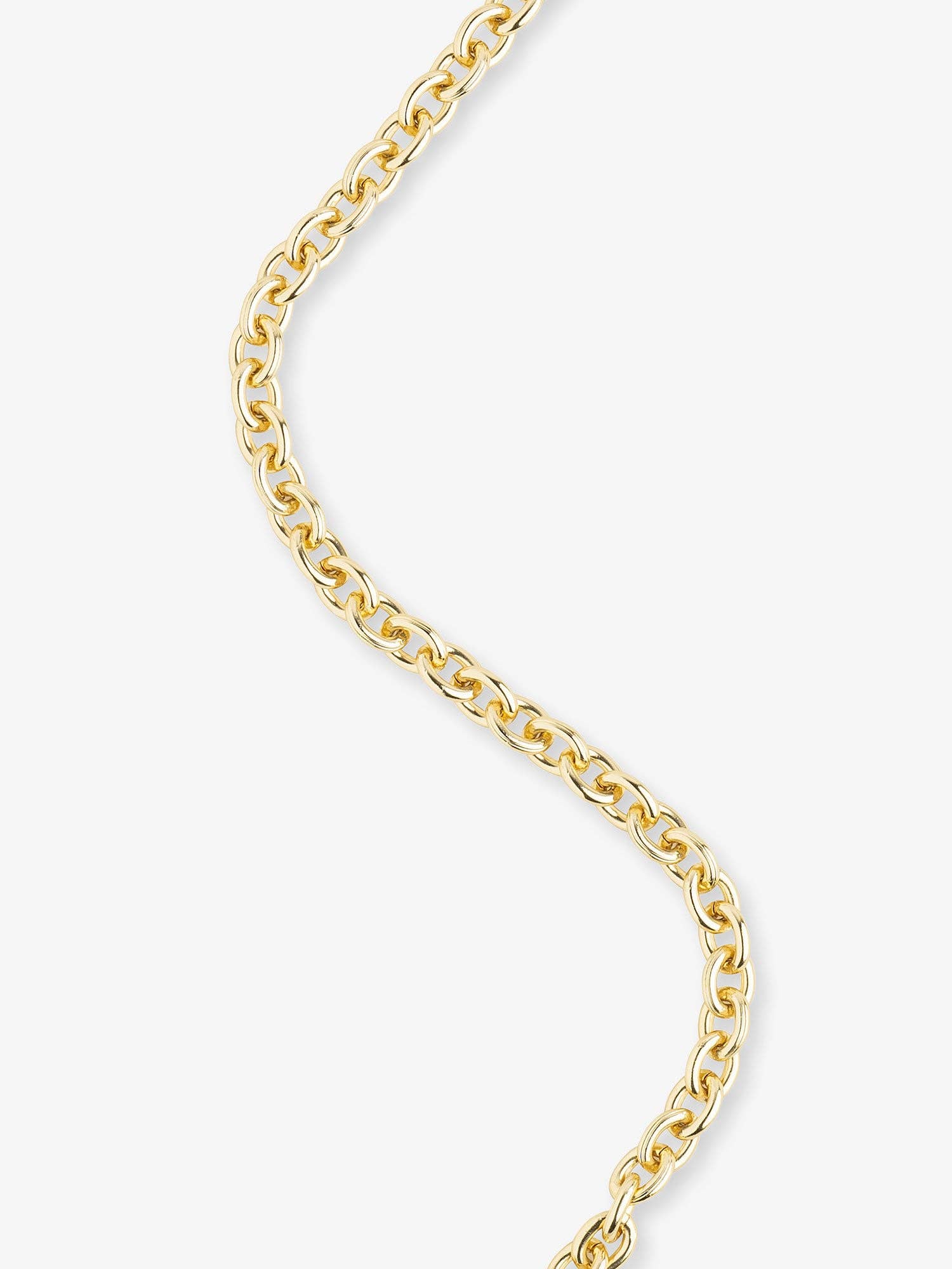 A close-up of a polished yellow gold curb chain necklace against a clean, off-white background.