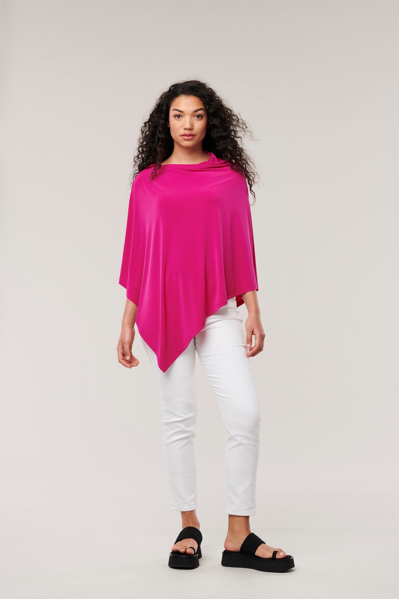 Hot pink Nadi 8-in-1 travel wrap scarf by Helene Clarkson Design, showcasing versatile styling options and soft, lightweight fabric.