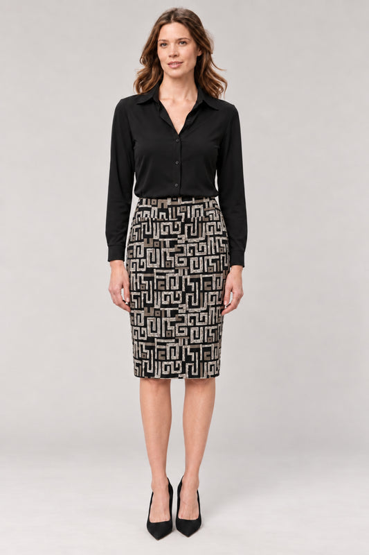 A woman modeling a black long-sleeve button-up shirt and a black-and-white geometric patterned pencil skirt, paired with black high heels, against a light gray studio background.